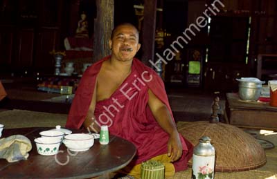 Buddhist monk with cigar at tea table 867434