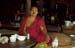 Buddhist monk with cigar at tea table 867434
