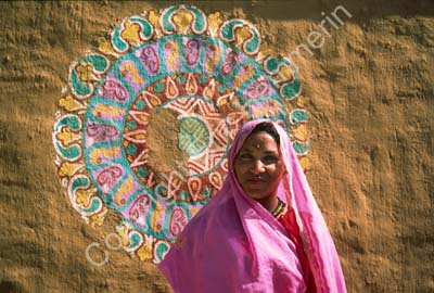 Woman in front of decoration on cottage Chowkidhani 005041