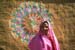 Woman in front of decoration on cottage Chowkidhani 005041