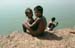 Children sitting by pond Puri 858835