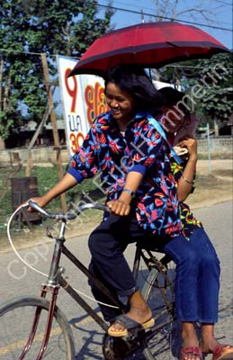 Girls on bicycle with umbrella 8710533